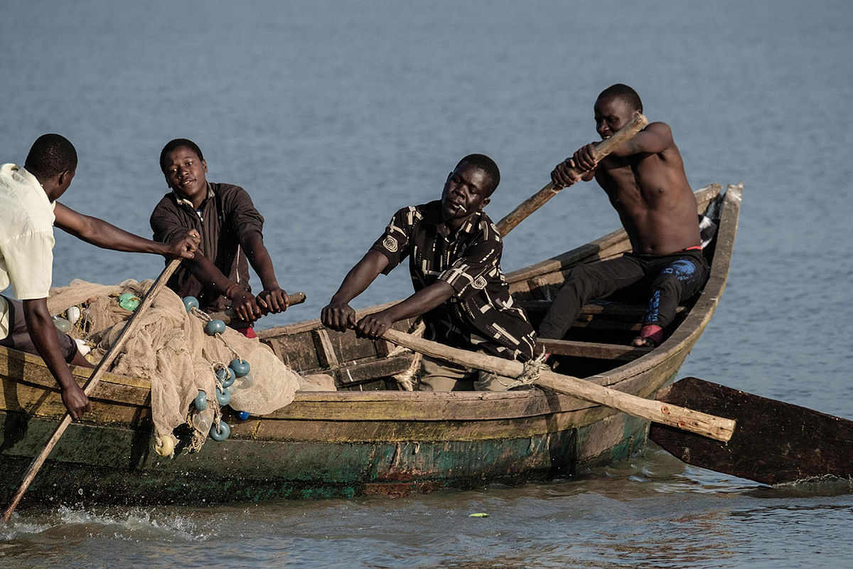 In this file photo taken on 2 October 2018 shows fishermen rowing a boat after the winds cleared water hyacinth from the surface of Lake Victoria in Kisumu, western Kenya. Photo: AFP