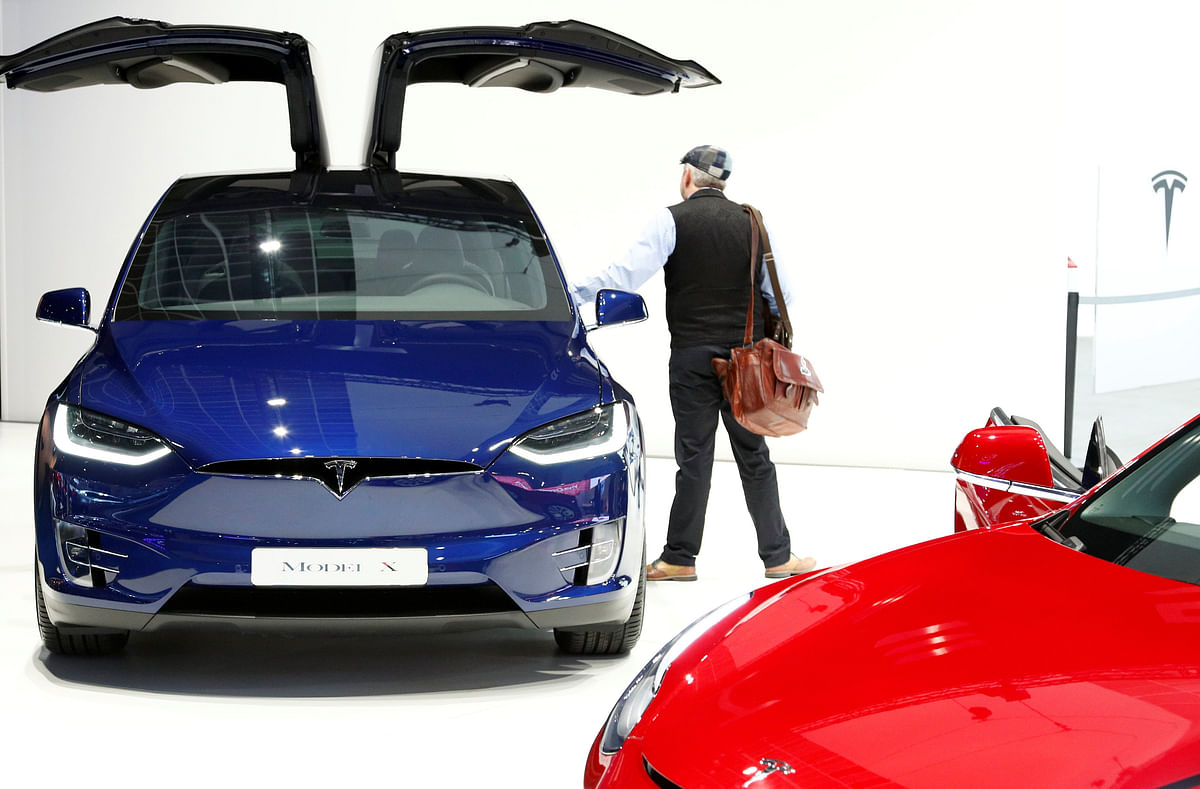 A visitor inspects a Tesla Model X electric vehicle at Brussels Motor Show, Belgium on 18 January. Photo: Reuters