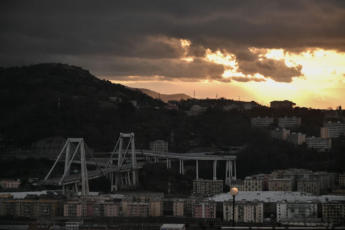 The sun rises over the eastern section of the remains of the Morandi Bridge on 9 February 2019 in Genoa, a day after the official start of demolition of the first meters of the bridge`s western section. Photo: AFP