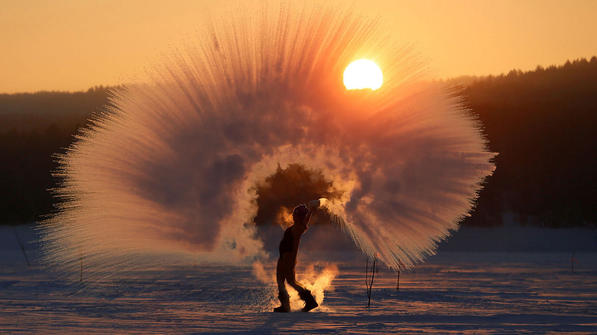 Winter outdoor sports enthusiast Olesya Ushakova poses in front of her acquaintance (not pictured) while throwing hot water into subzero air as she participates in the `Dubak Challenge`, a social media trend translating to an intense cold challenge that is recently popular in Russia, during sunset outside the Siberian city of Krasnoyarsk, Russia on 8 February 2019. Photo: Reuters