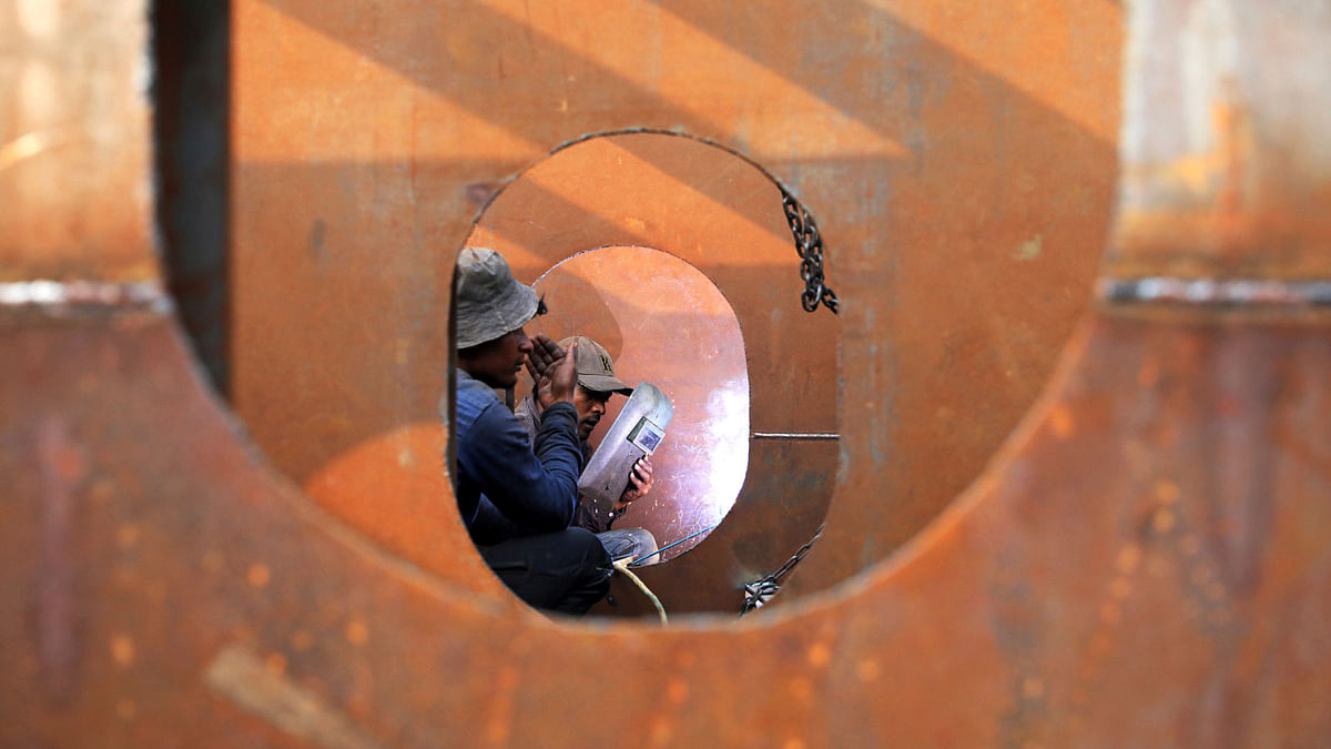 Workers weld iron sheets as they build a new ferry at a dockyard in Dhaka, Bangladesh, 7 February 2019. Photo: Reuters