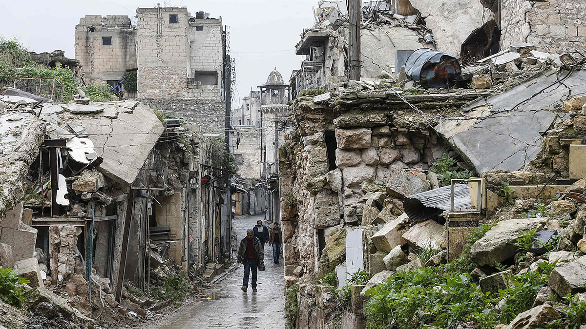 Syrian people walk amid destruction in the Bab al-Qinnasrin area in Aleppo`s Old city, on 10 February. AFP File Photo