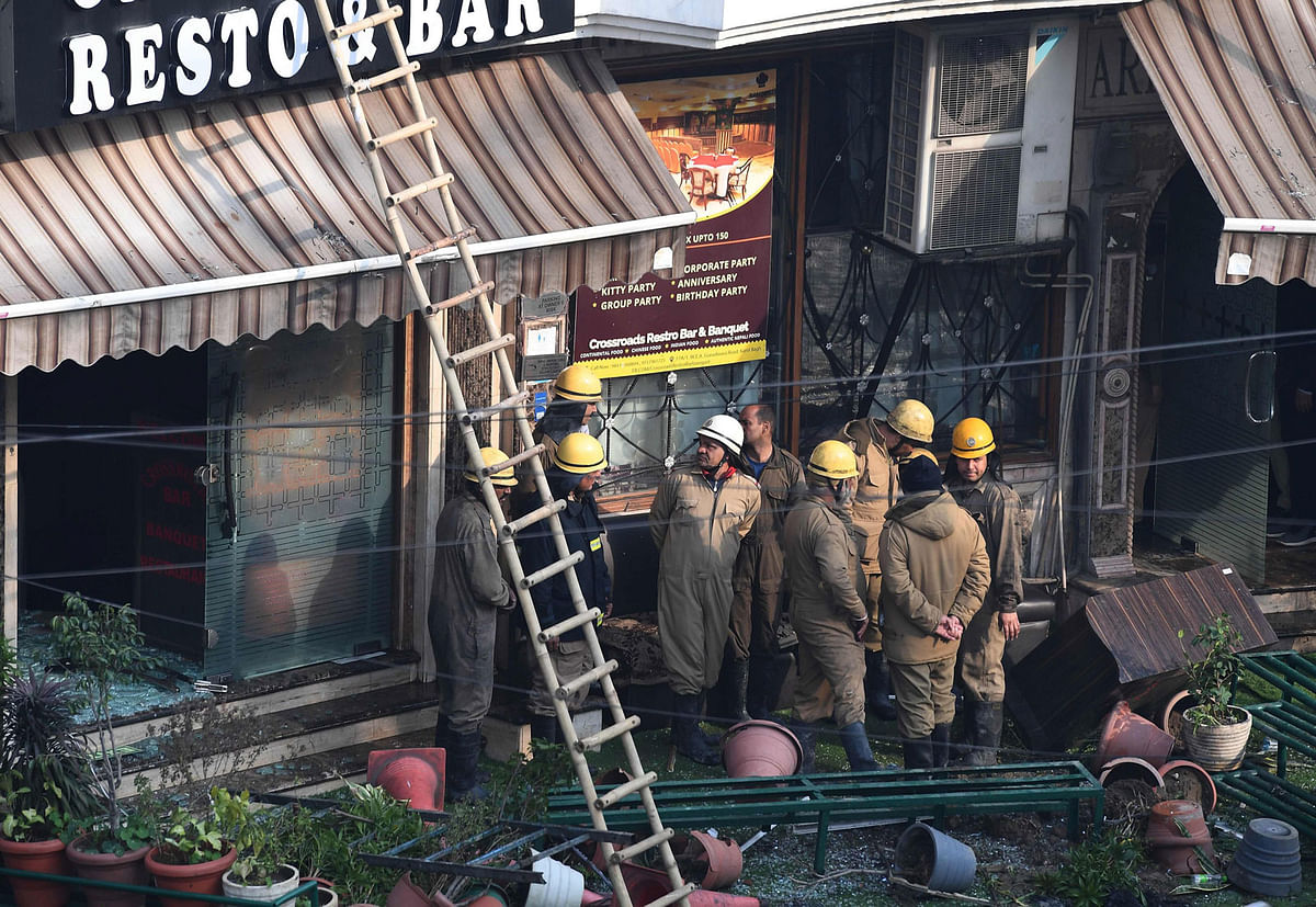 Delhi Fire Services (DFS) and Delhi police personnel stand outside Hotel Arpit Palace after extinguishing a fire that broke out on its premises in New Delhi on 12 February 2019. Photo: AFP