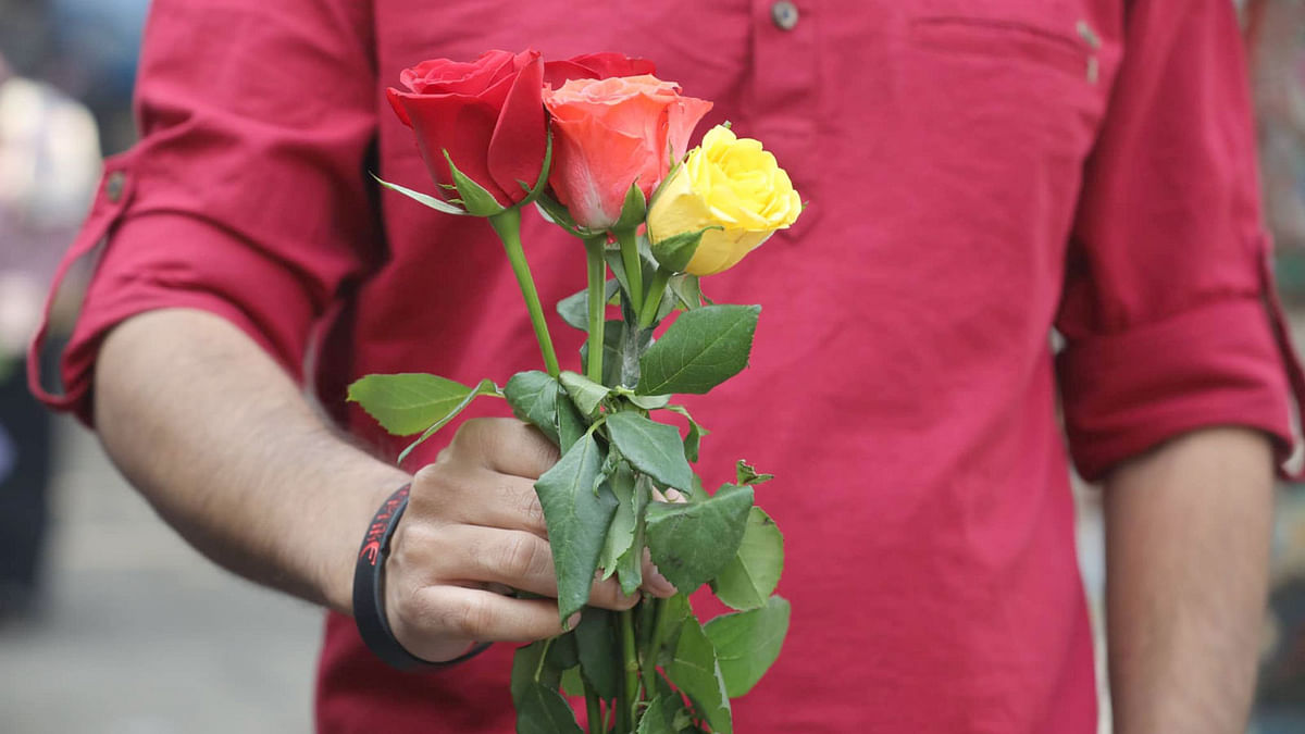 A man holds roses at the flower market of Shahbagh in Dhaka on 14 February. Photo: Abdus Salam