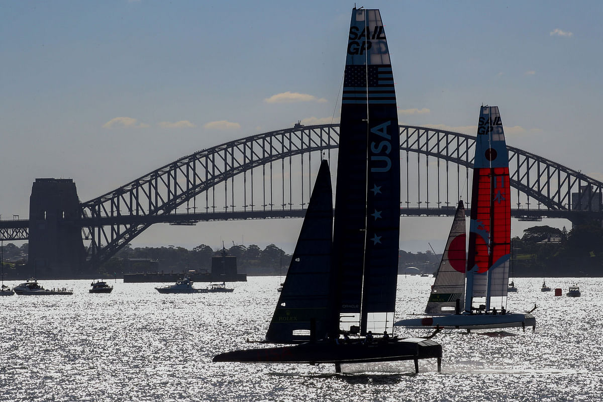 United States SailGP Team skippered by Rome Kirby and Japan SailGP Team skippered by Nathan Outteridge pass Sydney Harbour Bridge on day one of competition. 15 February 2019. Photo: Reuters