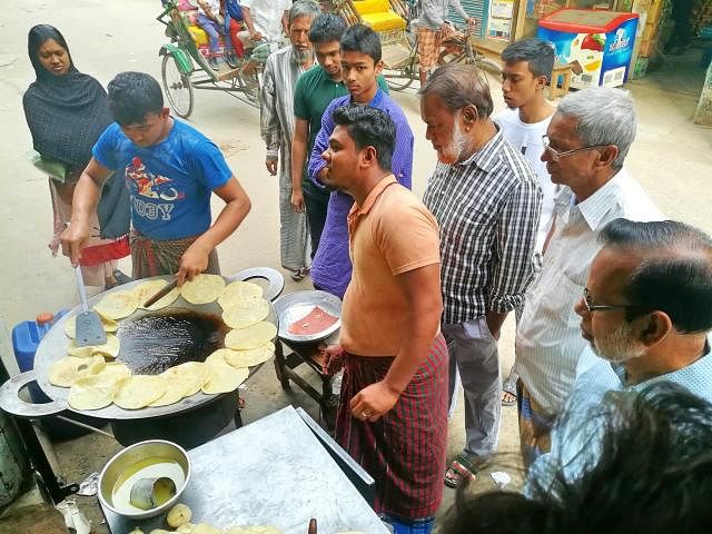 A cook makes `roti` as people waiting at a hotel in Mohammadpur of Dhaka to buy breakfast on 16 February. Photo: Sabina Yesmin