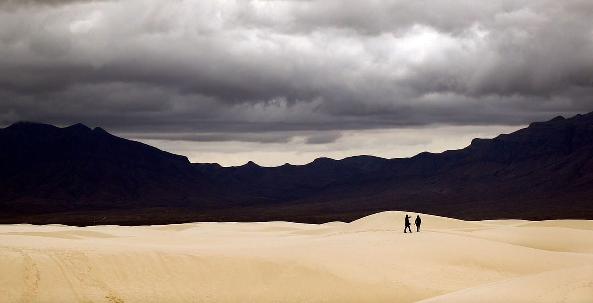 Visitors walk across dunes at White Sands National Monument as a rain storm passes, Sunday, on 10 February 2019, near Alamogordo, New Mexico, US. Photo: AP