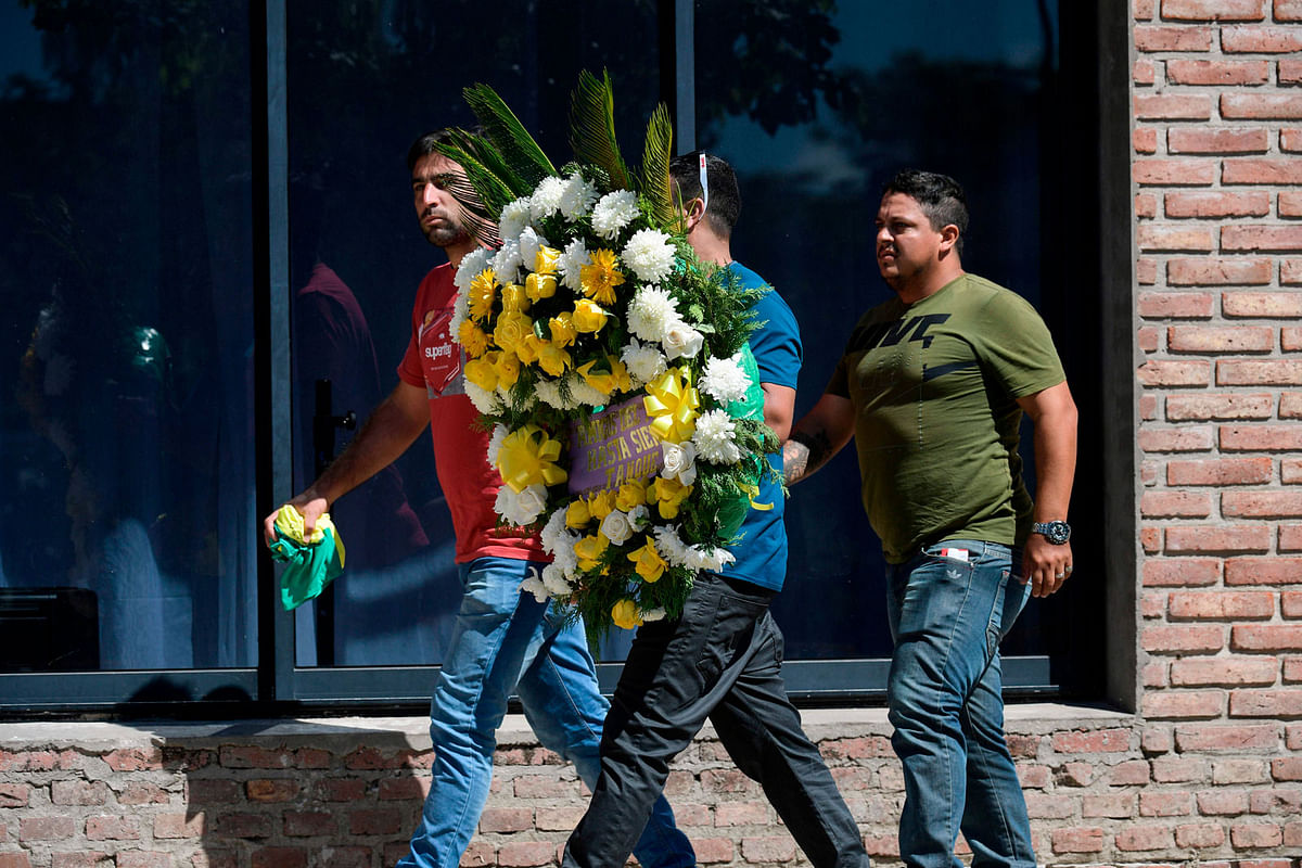 People carrying a wreath arrive at the Club Atletico y Social San Martin to attend the wake of late Argentine football player Emiliano Sala, in Progreso in Santa Fe province, Argentina on 16 February, 2019. Photo: AFP