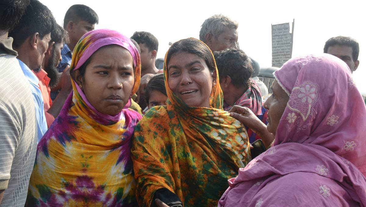 A woman cries while two others trying to console her after the fire gut her home in Bheramarket slum, Chaktai, Chattogram early Sunday. Photo: UNB