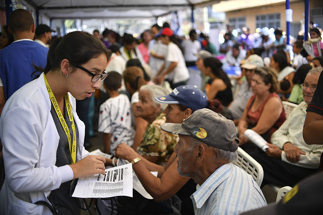 Volunteer of the `Aid and Freedom Coalition` movement assists people seek medical attention in the Macarao neighbourhood in Caracas, on 17 February 2019. Photo: AFP