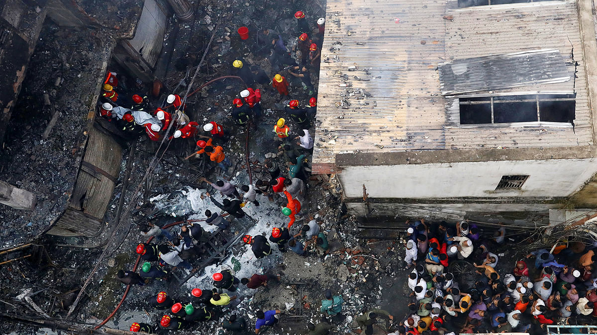 A dead body is carried out from a burnt warehouse in Dhaka. Photo: Reuters