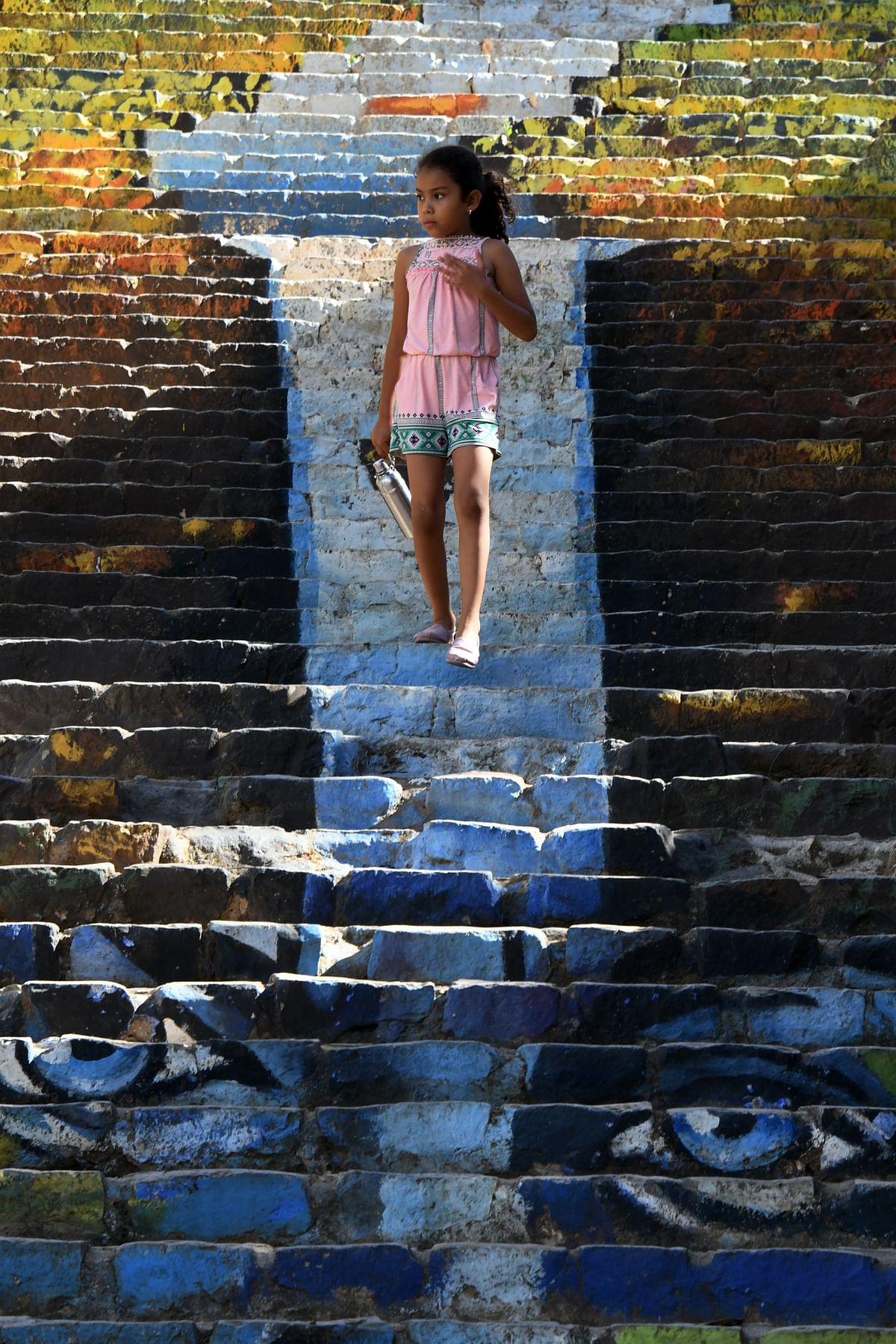 A girl walks down a stairs on 22 February 2019 in the Honduran municipality of Cantarranas near Tegucigalpa, where murals were painted in honour of slain Honduran environmental Berta Caceres ahead of the third anniversary of her death on 2 March. Photo: AFP