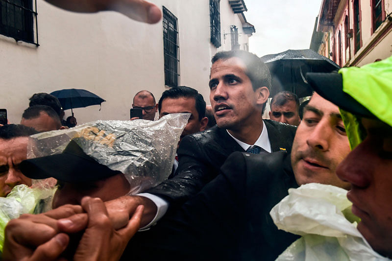 Venezualan opposition leader and self-declared acting president Juan Guaido (C) is greeted by people after holding a meeting with members of a multinational support group in the framework of the Lima Group to discuss a joint strategy to resolve Venezuela`s crisis, at the Foreign Ministry in Bogota, on 25 February. Photo: AFP