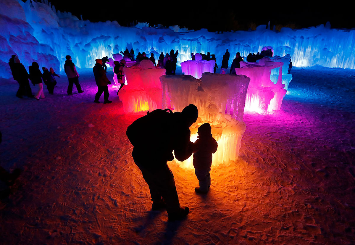 In this 26 January 2019 photo, visitors race down the side-by-side tunnels of a 97-foot ice slide at Ice Castles in North Woodstock, NH. The winter wonderland is one of six in North America. Photo: AP