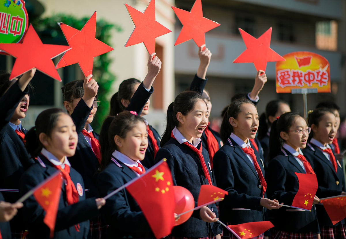 Students hold Chinese flags and cutouts of red stars as they perform a song titled `Me and my country`, at a ceremony marking the primary school`s new semester in Hohhot, Inner Mongolia Autonomous Region, China on 28 February 2019. Photo: Reuters