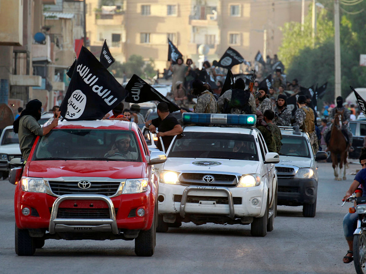 Militant Islamist fighters waving flags, travel in vehicles as they take part in a military parade along the streets of Syria`s northern Raqqa province on 30 June, 2014. Photo: Reuters