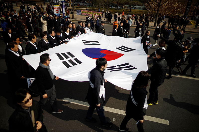 People carrying a South Korean national flag march during a re-enactment of the historic March First Independence Movement against Japanese colonial rule, in central Seoul, South Korea on 1 March. Reuters File Photo