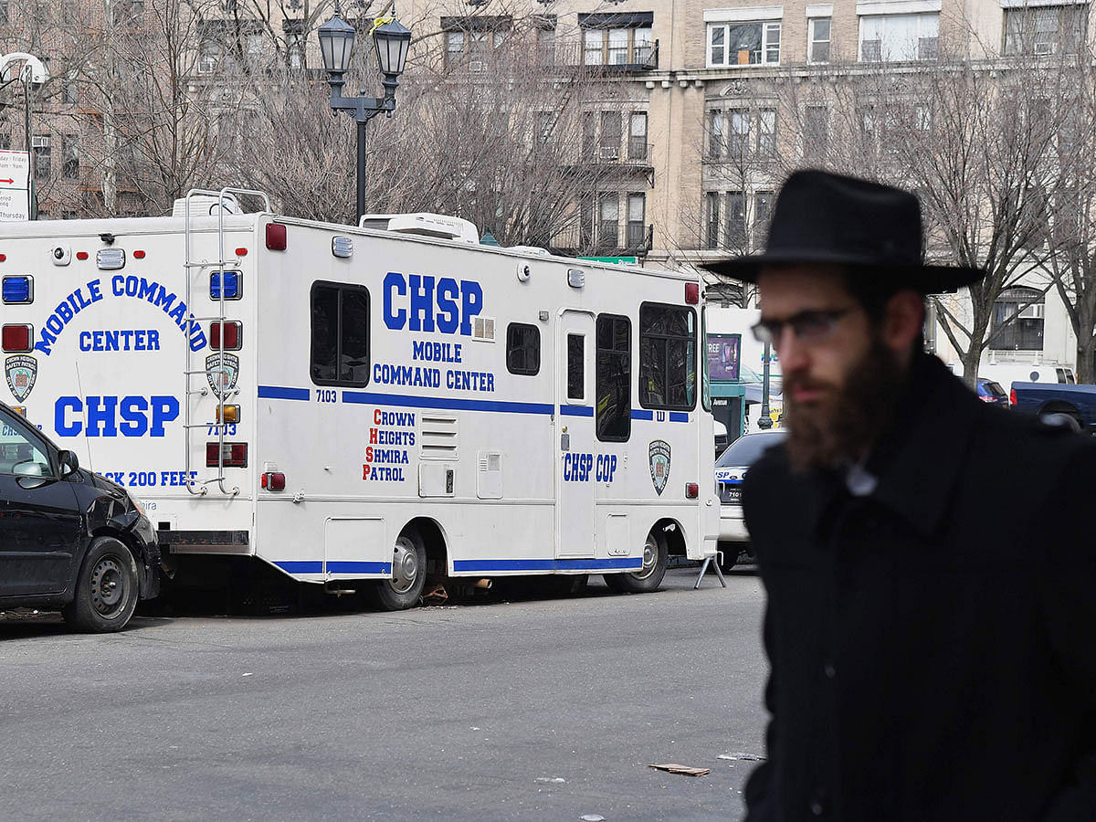 An Orthodox Jew walks past a `Crown Heights Shmira Patrol` security vehicle in the Brooklyn neighbourhood of Crown Heights on 27 February in New York. AFP File Photo