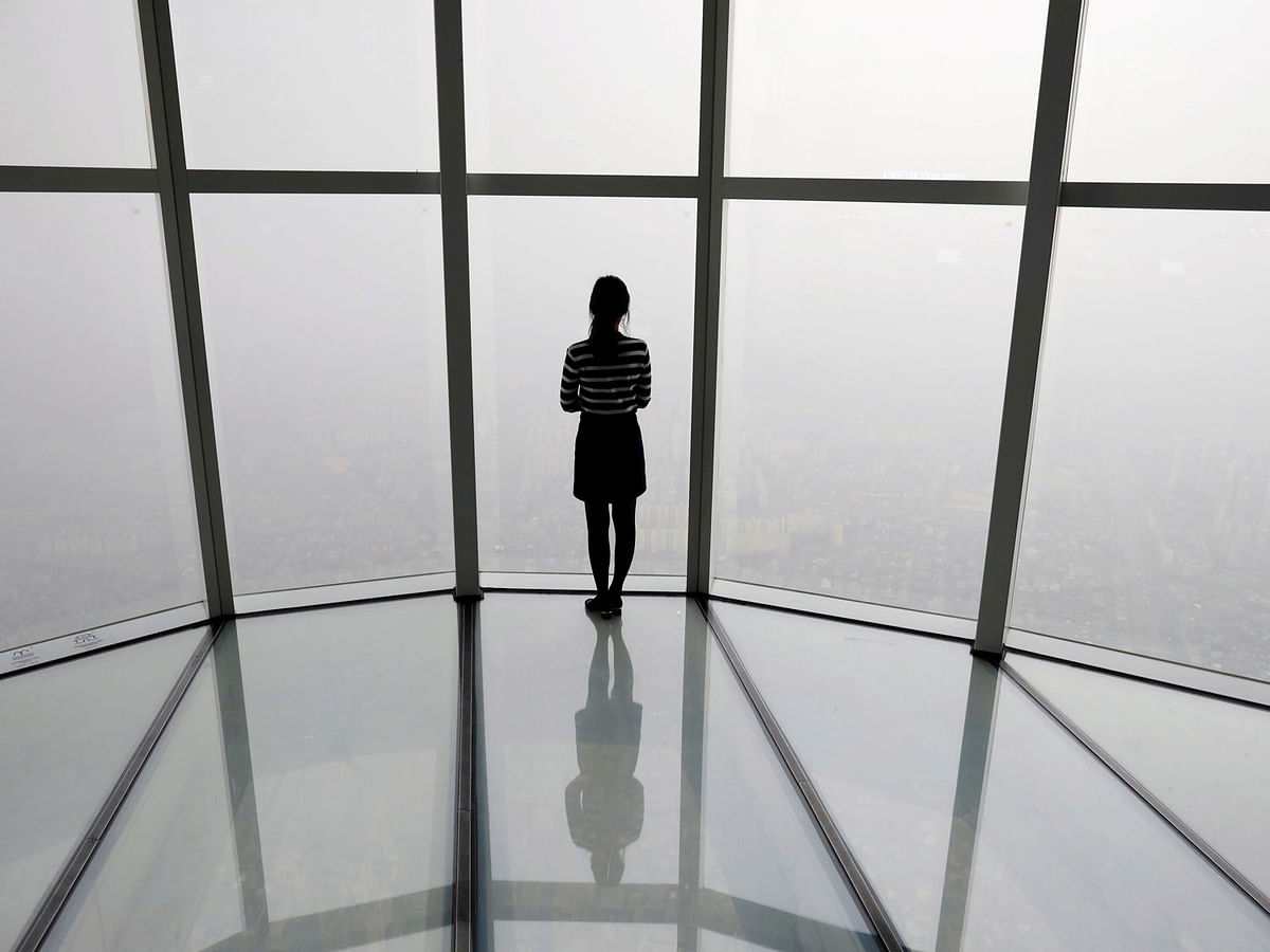 A woman looks at a view of Seoul shrouded by fine dust during a polluted day in Seoul, South Korea, 6 March 2019. Photro: Reuters