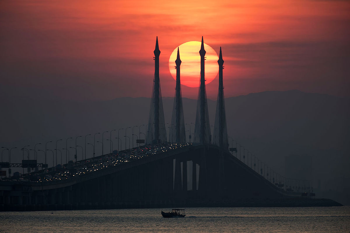 Sun rises over Penang bridge in Penang island, Northern Malaysia on 7 March. Photo:AP