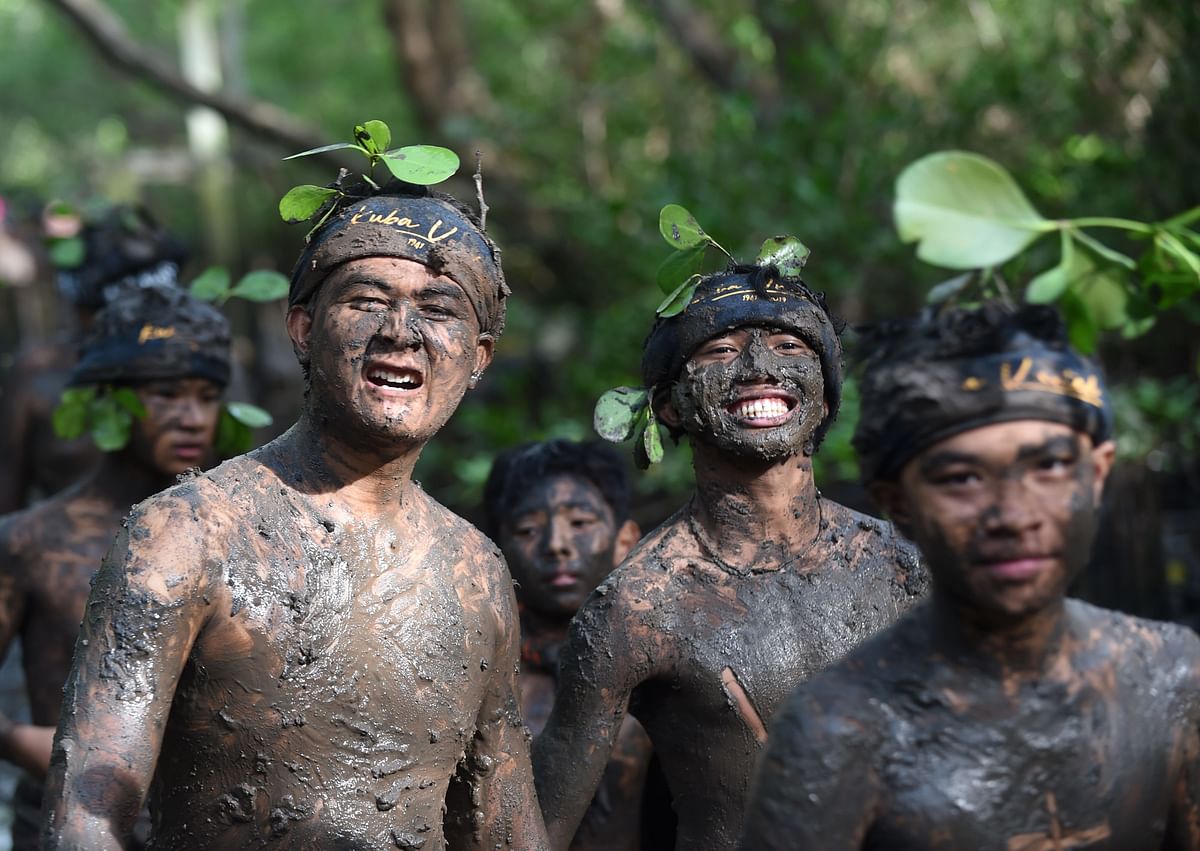 Balinese people put mud on their body during a traditional mud bath known as Mebuug-buugan, in Kedonganan village, near Denpasar on Indonesia`s resort island of Bali on 8 March 2018. Photo: AFP