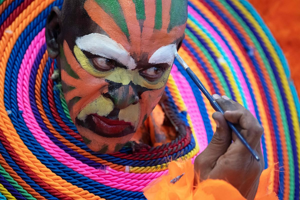 A man makes up his face as he prepares to work at the booth of the Dominican Republic at the ITB (Internationale Tourismus Boerse) international tourism fair in Berlin on 8 March 2019. Photo: AFP