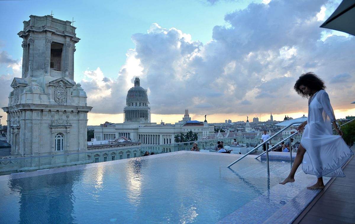 A tourist stands by the swimming pool on the rooftop of the Gran Manzana Hotel in Havana, on 11 February 2019. Cuba attracts wealthy tourists with five-stars hotels, spas and luxury brands. Photo: AFP