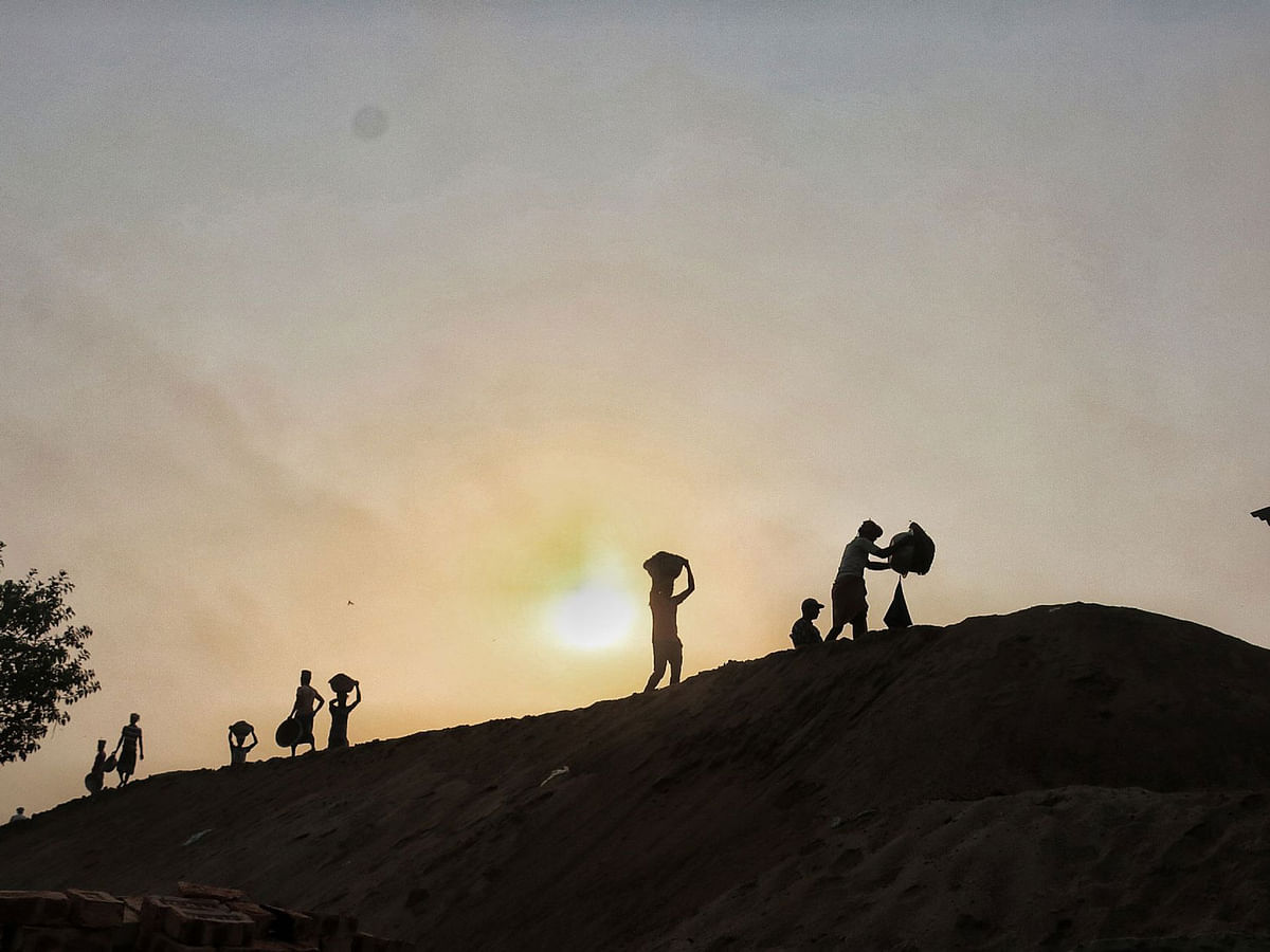 Workers carrying their loads as the sun rises at Koyla Ghat in Khulna on 10 march. Photo: Saddam Hossain