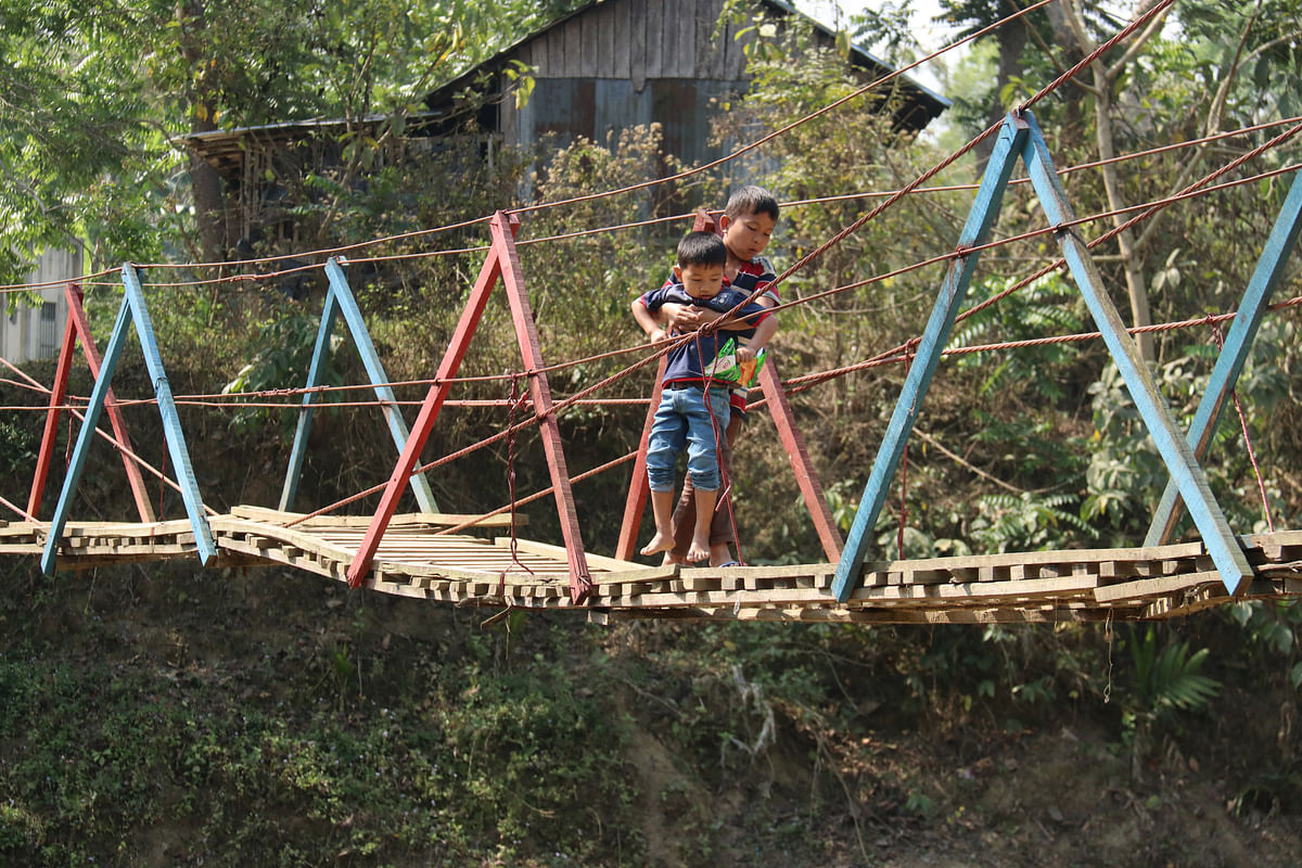 Children crossing the canal Dolia on a hanging bridge at Barajhala, Khagrachhari on 10 March. Photo: Nerob Chowdhury