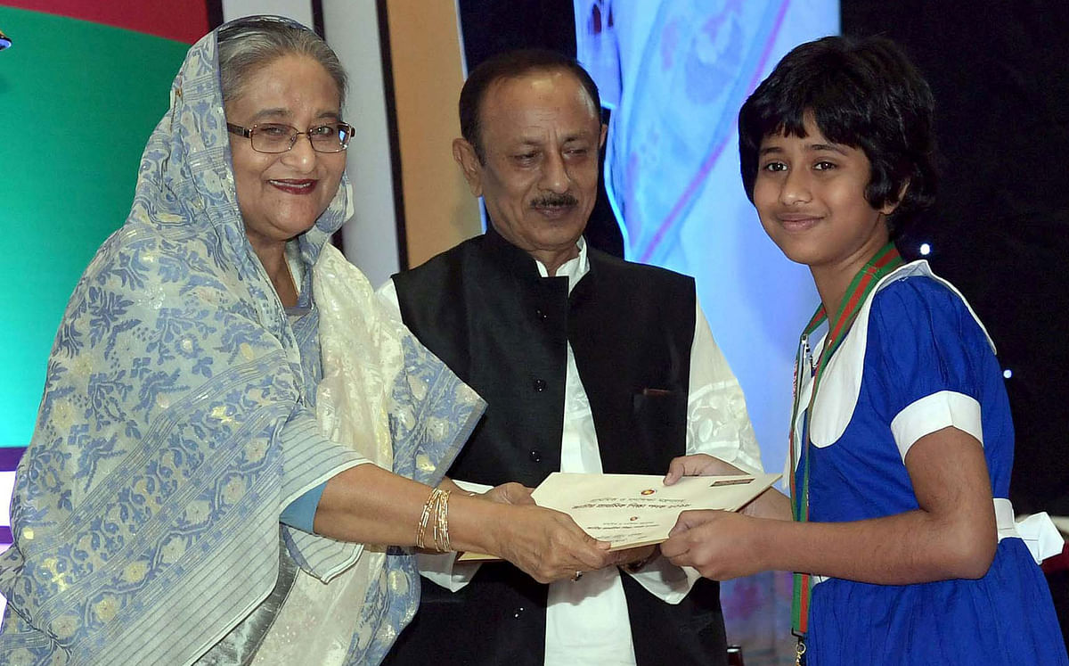 Prime minister Sheikh Hasina hands over an award of ‘Primary Education Padak’ to a student at a programme at the inauguration of the National Primary Education Week-2019 at Bangabandhu International Conference Centre in Dhaka on Wednesday. Photo: PID