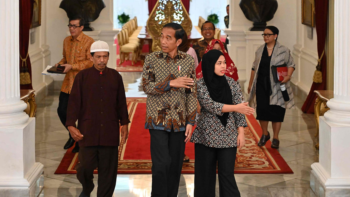 Indonesia`s president Joko Widodo (C) walks together with Siti Aisyah (front R) and her family after their meeting at palace in Jakarta, on 12 March 2019. Shock and delight rippled through the Indonesian town of Sindangsari on March 11 as residents got word that a local woman accused of assassinating the North Korean leader`s half-brother had been freed. Photo: AFP