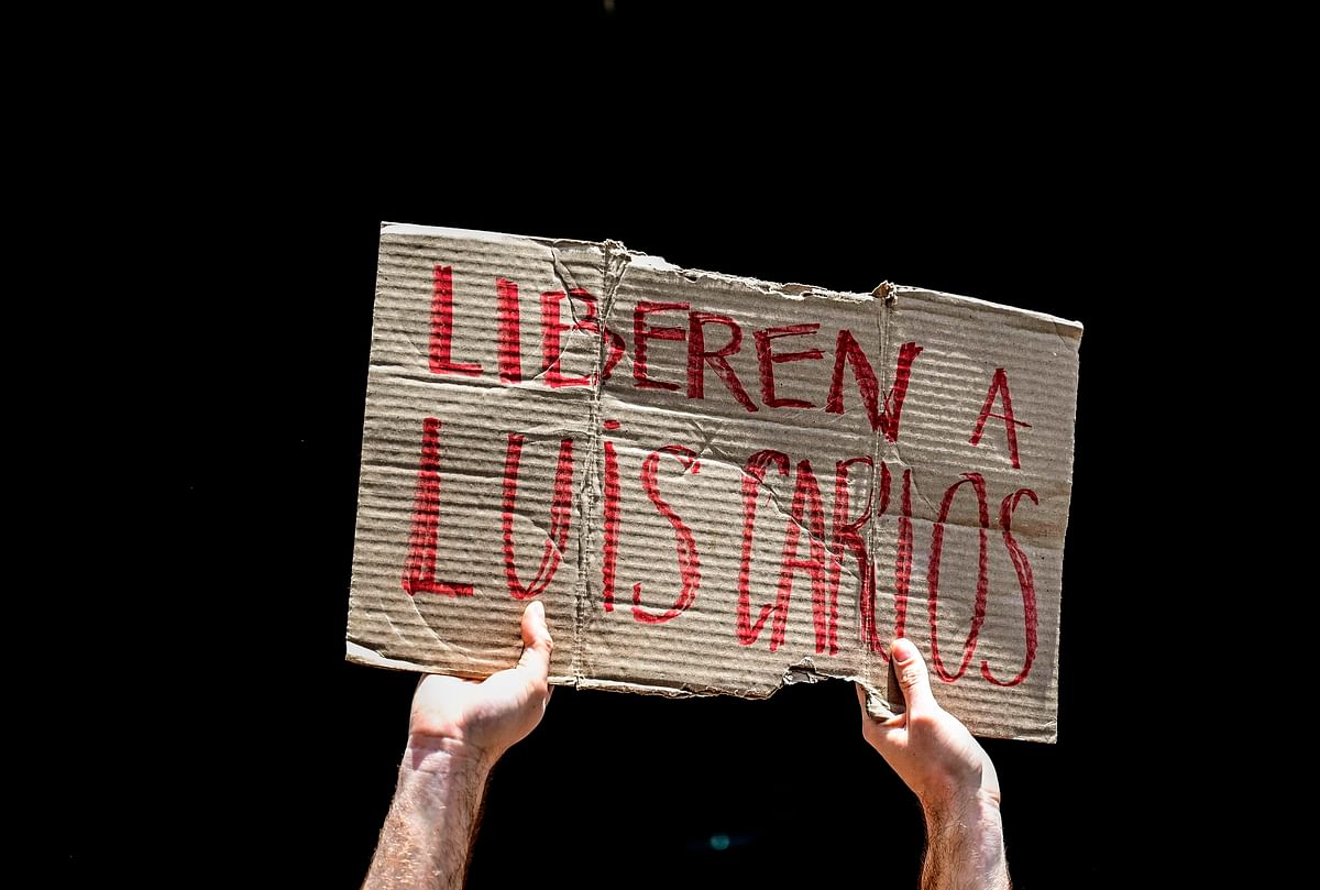 A man holds a banner that reads `Free Luis Carlos` during a demonstration asking for the release of Venezuelan journalist and human rights activist Luis Carlos Diaz, outside the Public Prosecutor`s office in Caracas on 12 March 2019. Photo: AFP