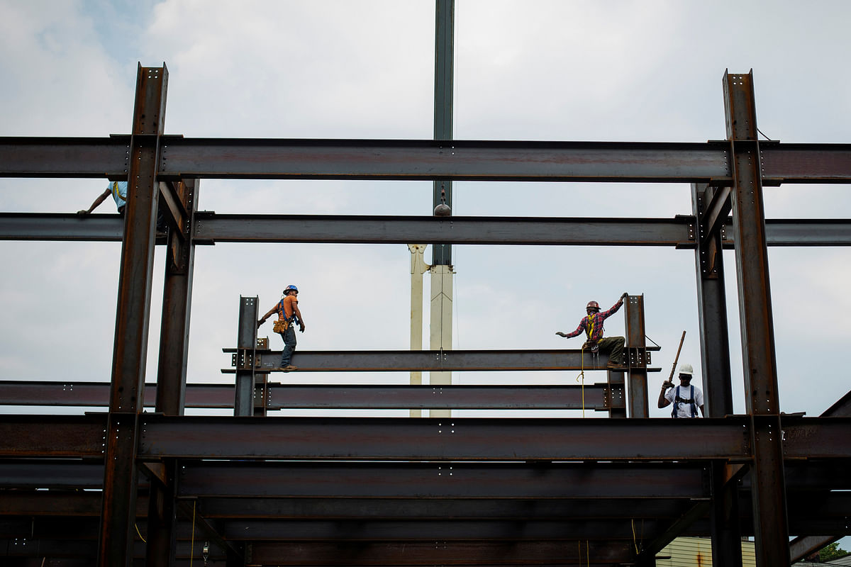 Iron workers install steel beams during a hot summer day in New York on 17 July 2013. Reuters File Photo