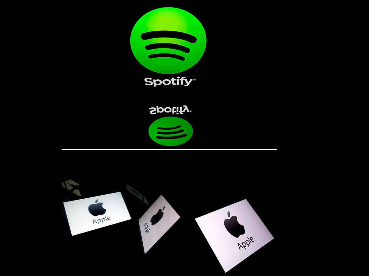 This combination created on 13 March 2019 of file illustrations displayed on tablet screens shows the logo of the US multinational technology company Apple (bottom, 18 February 2019 in Paris) and the logo of online streaming music service Spotify (19 April 2018 in Paris). Photo: AFP