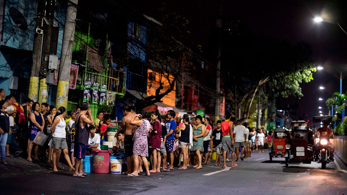 Residents of Addition Hills in Madaluyong City, Manila, queue to receive water distributed on water tank truck and fire trucks on 15 March. Photo: AFP