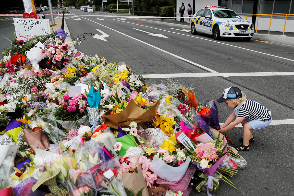 A boy places flowers at a memorial as a tribute to victims of the mosque attacks, near a police line outside Masjid Al Noor in Christchurch, New Zealand, on 16 March 2019. Photo: Reuters