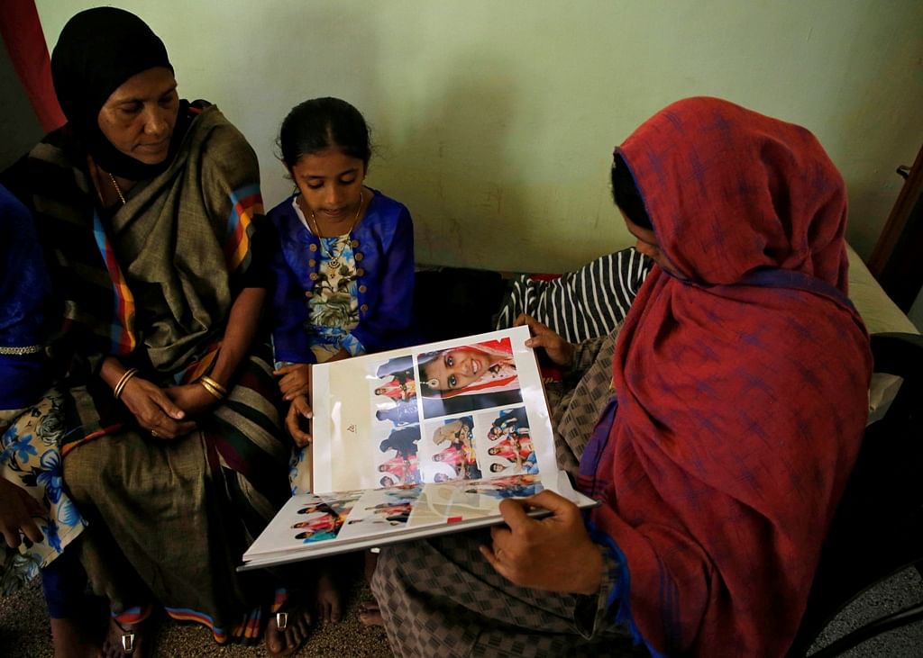 Relatives and neighbours look at the wedding album of Anzi Ali Bhava, who was killed in Friday's mosque attacks in New Zealand, at her parent's house in Kodungalloor town in the southern state of Kerala, India, 17 March 2019. Photo: Reuters