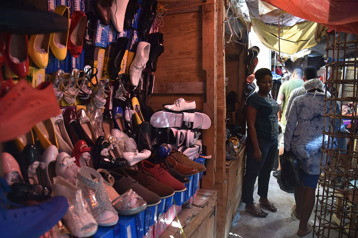 Cubans look for clothes in a market, in the center of Port-au-Prince, on 4 February 2019. Many Cuban merchants come to Haiti every week in order to buy clothes and sell them on the markets in their home country. Many of them say they come to Haiti because of the low prices and the proximity of the island. Photo: AFP