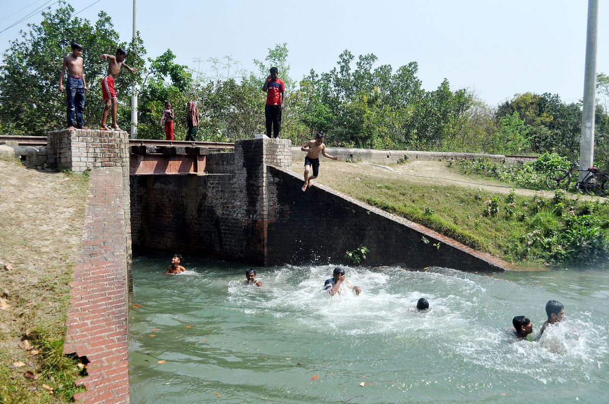 Children jump into canal at Bamanpara, Bheramara in Kushtia on 18 March, 2019. Photo: Touhidi Hassan