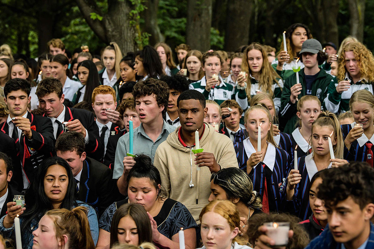 Students hold candles during a vigil in Christchurch on March 18, 2019, three days after a shooting incident at two mosques in the city that claimed the lives of 50 Muslim worshippers. New Zealand will tighten gun laws in the wake of its worst modern-day massacre, the government said on March 18, as it emerged that the white supremacist accused of carrying out the killings at two mosques will represent himself in court. AFP