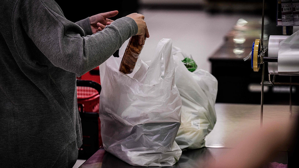 In this picture taken on 7 November 2018, a woman packs her shopping into a plastic bag in a supermarket in Chiba. AFP File Photo