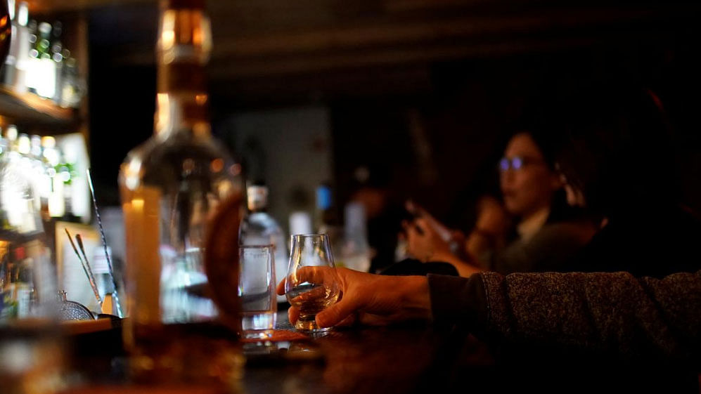 A man drinks American whiskey at a bar in Shanghai, China, on 6 April 2018. -- Photo: Reuters