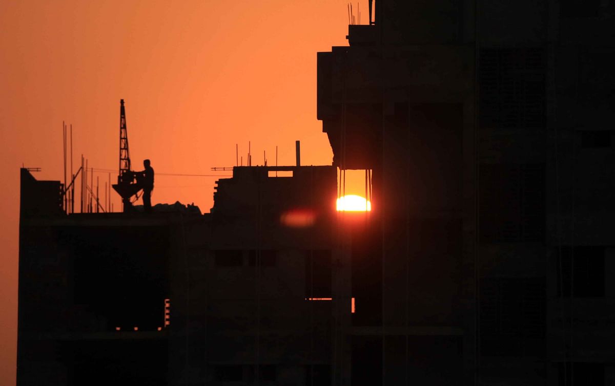 A worker busy working on the terrace of a building during the sunset at Nazrul Avenue, Kandirpar, Cumilla. 19 March 2019. Photo: Emdadul Haque
