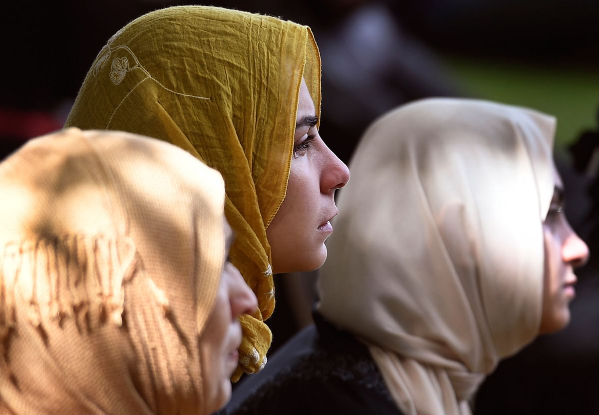 Members of the public look on during congregational Friday prayers and two minutes of silence for victims of the twin mosque massacre, at Hagley Park in Christchurch on 22 March, 2019. Photo: AFP