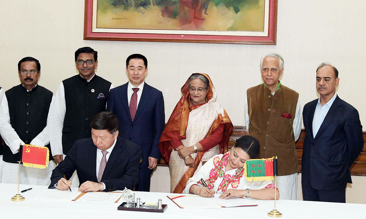 Bangladesh Awami League international affairs secretary Shammi Ahmed and Song Tao sign the MoU on behalf of their respective parties in presence of prime minister Sheikh Hasina at Ganabhaban, Dhaka. Photo: PID