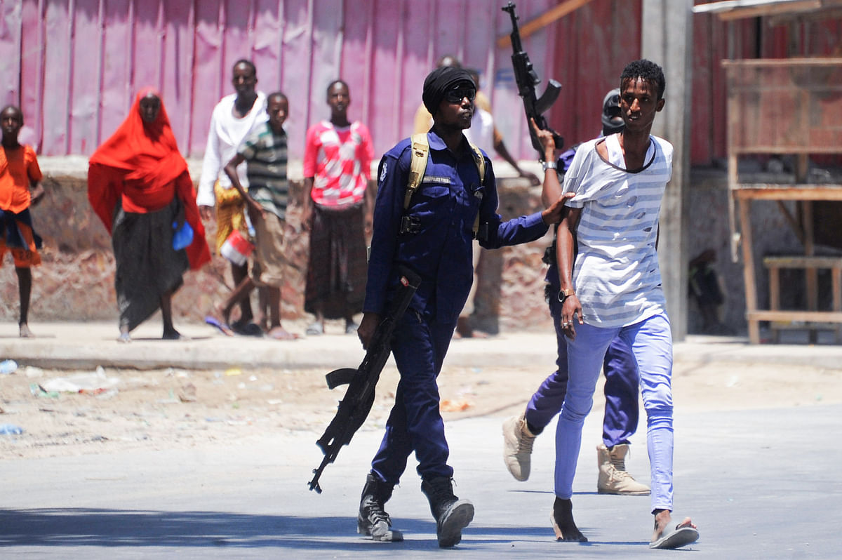Somali soldiers arrest a civilian close to the scene of two explosions set off near the ministries of public works and labour in Mogadishu on 23 March, 2019. Photo: AFP