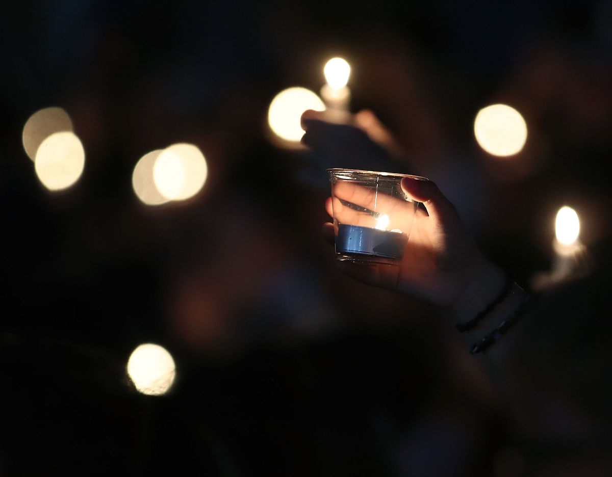 In this file photo taken on 15 February 2018, students and family members hold candles during a vigil for victims of the mass shooting at Marjory Stoneman Douglas High School on 14 February 2018, at Pine Trail Park, in Parkland, Florida.