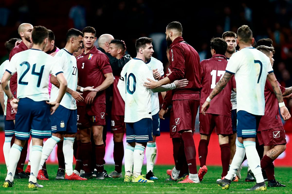 Argentina`s forward Lionel Messi (C) and teammates congratulate Venezuela`s players at the end of an international friendly football match at the Wanda Metropolitano stadium in Madrid on 22 March 2019 in preparation for the Copa America to be held in Brazil in June and July 2019. Photo: AFP