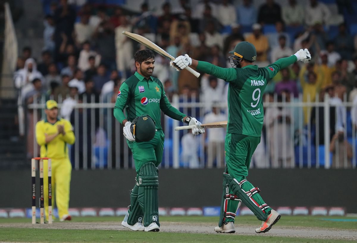 Pakistan cricketer Haris Sohail reacts as he celebrates his century (100 runs) with Imad Wasim (R) during the first one-day international (ODI) cricket match between Pakistan and Australia in Sharjah on 22 March 2019. Photo: AFP
