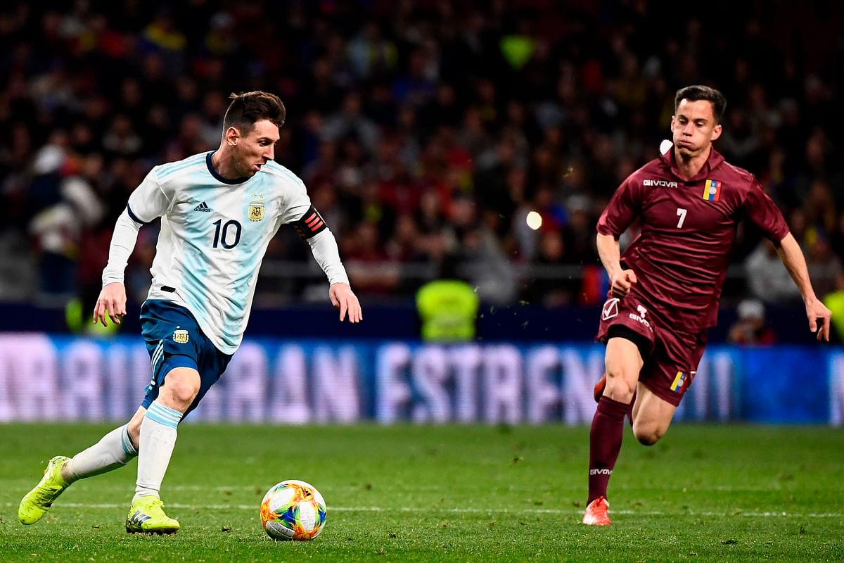 Argentina`s forward Lionel Messi (L) runs with the ball next to Venezuela`s midfielder Juanpi during an international friendly football match at the Wanda Metropolitano stadium in Madrid on 22 March 2019 in preparation for the Copa America to be held in Brazil in June and July 2019. Photo: AFP